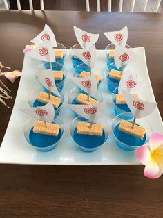 small desserts are arranged on a plate with flags