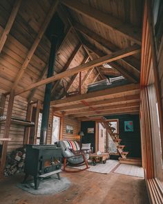 the inside of a log cabin with wood burning stove and large windows on both sides