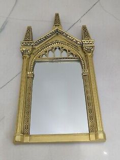 an ornate gold framed mirror on a marble counter