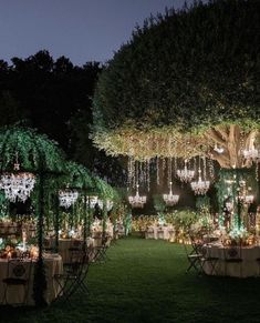 an outdoor dinner setup with chandeliers and tables set up for the evening party