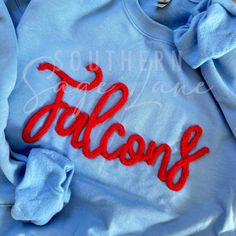 Pullover embroidered with cursive chenille The word Falcons with your team colors. Chenille Color Options: White, Black, Crimson, Maroon, Royal, Navy, Sage, Olive, Pine, Gray, Pale Blue, Aqua Blue, Teal, Mushroom, Bright Yellow, Yellow Gold, Cream, Coral Orange, Neon Orange, Purple. Please message us for custom colors or with any questions. *We use only the highest quality Gildan Heavy Blend Unisex Sweatshirts Crew Neck T-shirt With Letter Embroidery For College, Fall College Embroidered Tops, Embroidered Fall Tops For College, Collegiate Long Sleeve T-shirt With Letter Embroidery, Varsity T-shirt With Letter Embroidery, Varsity Tops With Embroidered Logo For Fall, Varsity T-shirt With Letter Embroidery For College, School Spirit T-shirt With Letter Embroidery For Fall, Fall School Spirit T-shirt With Letter Embroidery