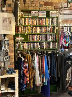 a clothing store filled with lots of different types of shirts and ties on display in front of a brick wall