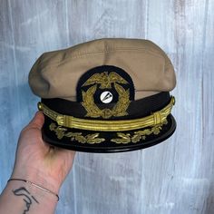 This Is An Amazing Relic From Ww2. This Hat Is From Either The U.S. Navy Or A Ww2 Era Shipman Hat From A Captain. The Only Ones Similar We Could Find Was Parts Of Both So We Aren’t Quite Sure What This Guy Is. This Has Insanely Beautiful Real Gold Beads On The Insignia And Gold String For The Regalia On The Visor Part. The Inside Has A Odd Polyester Plastic Liner That I Haven’t Seen Before And Is As Is. This Hats In Beautiful Condition With No Major Stains, Rips Or Tears. This Does Have Some Black Speckling We Have Not Attempted To Remove On The Back. Perfect For A Ww2 Collector! Vintage Khaki Hat With Short Brim, Vintage Beige Visor Hat, Vintage Brimmed Khaki Hat, Us Navy Hat, Vintage Khaki Brimmed Hat, Vintage Beige Six-panel Hat, Black Brimmed Military Hat, Brown Military Visor Hat, Brown Military Brimmed Hat