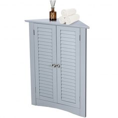 a blue cabinet with two doors and some towels on top of it, in front of a white background