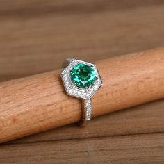 It is a genuine emerald ring(lab emerald). The emerald is 7mm*7mm round, weight about 1.29 carats. The basic metal is sterling silver and plated with rhodium. To change the metal to a solid gold (white/rose) or platinum is also available, please ask for a quotation if you want. You can also go to my shop Home for more elegant rings: https://www.etsy.com/shop/godjewelry?ref=hdr_shop_menu Emerald is May birthstone. More emerald rings: https://www.etsy.com/shop/godjewelry?ref=hdr_shop_menu&sect May Birthstone Emerald Ring With Halo Design, Emerald Ring With Halo Design For May Birthstone, Round Emerald Ring With Halo Design For May Birthstone, Emerald Diamond Ring With Halo Design, Emerald Ring With Halo Design, Round Emerald Halo Promise Ring, Emerald Halo Promise Ring, Emerald Halo Ring For Promise, May Birthstone, Silver Emerald Ring With Halo Design For May Birthstone