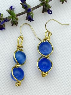 Blue-Purple round stones with gold wire. Lead and nickel free Blue Wire Wrapped Hoop Earrings, Blue Wire Wrapped Round Hoop Earrings, Wire Wrapped Copper Drop Earrings, Blue Copper Wire Earrings With Ear Wire, Purple Wire Wrapped Drop Earrings, Gold Wire-wrapped Earrings, Brass Wire Wrapped Drop Earrings, Gold Wire-wrapped Wrap Earrings, Gold Wire Wrapped Round Earrings