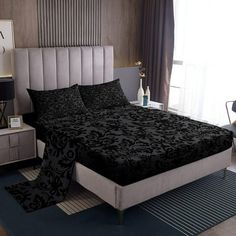 a black and white bed in a bedroom next to a window