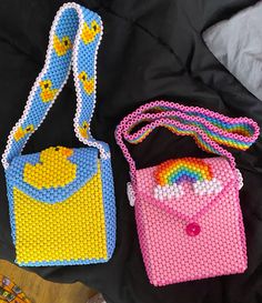 two purses made out of beads sitting on top of a bed