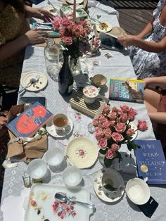 people sitting at a table with plates and flowers