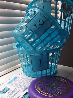 a purple frisbee sitting next to a blue basket