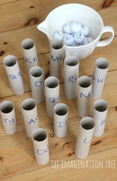 a bunch of toilet paper rolls sitting on top of a wooden table next to a white bucket