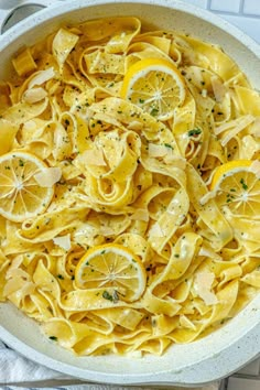 a white bowl filled with pasta and lemon slices