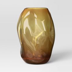 a brown glass vase sitting on top of a white table