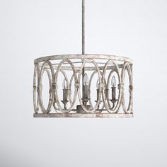 a white chandelier hanging from a metal rod with three lights on each end