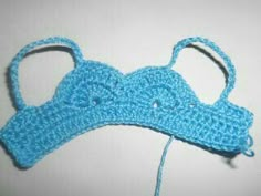 a crocheted blue headband with two ears