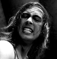 a black and white photo of a man with long hair in the middle of his face