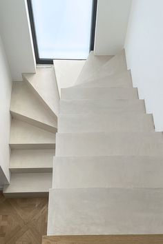 a white staircase leading up to a skylight