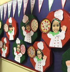 a group of children's paper cutouts are displayed on the wall in front of them