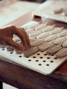 a person's hand on a computer keyboard that is made out of wood planks