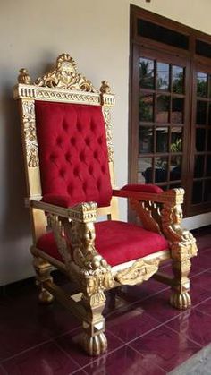 a red and gold chair sitting on top of a purple floor next to a window