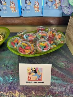 there are many small plastic cups with candy in them on the table next to each other