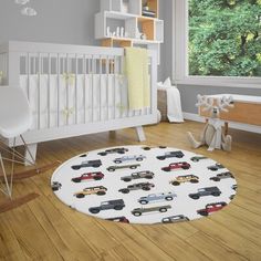 a baby's room with a white crib and toy cars on the floor