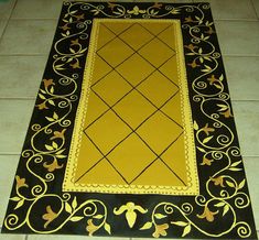 a black and yellow area rug with gold designs on the floor in front of a white tile floor