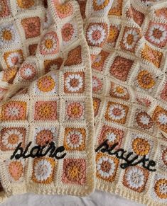 two crocheted afghans sitting on top of a white bed spread with black writing