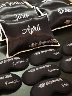 black and white pillows with embroidered names on them sitting on a table next to each other