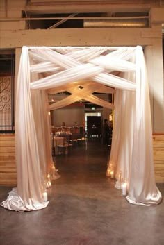 a white wedding arch decorated with candles