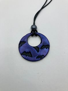 Black Polymer Clay with purple Mica Powder to shine. Pendant is 1 1/2 inches. Waxed cord is 16 inches in length. This Handmade necklace is perfect for Halloween. This necklace is fully hand made and hand finished so slight variations in color/finish should be expected. Mica Powder color will shine differently in different light. Adjustable Vampire Necklace For Halloween, Adjustable Black Themed Necklace, Purple Halloween Jewelry Gift, Unique Black Halloween Necklace, Adjustable Nickel Free Halloween Necklaces, Gothic Purple Jewelry For Halloween, Gothic Purple Necklace For Halloween, Handmade Halloween Necklace, Clay Bat