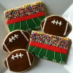 decorated cookies with footballs and sprinkles on a plate