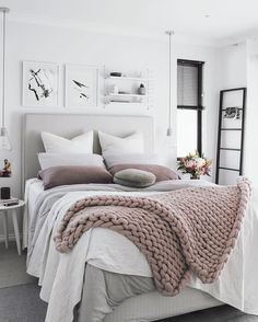 a bed with white sheets and blankets on top of it