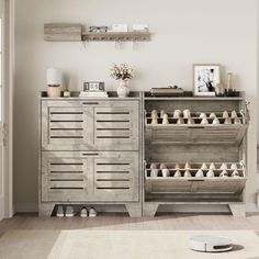 a room with a large cabinet and several pairs of shoes on the floor in front of it