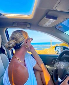 a woman sitting in the driver's seat of a car