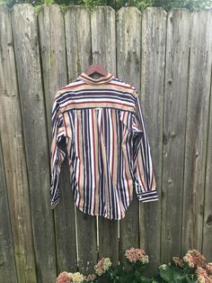 This is an awesome button up and is ready for your life. If you want to look amazing, this is the perfect shirt for you. It is in great condition, but has some small spots on the back of the collar, pictured. There are no rips, holes or smells. Measurements: Pit to pit: 22 3/4 inches Collar to bottom front: 26 1/4 inches Collar to bottom back: 29 1/2 inches Sleeve Length (from collar): 30 inches Size on tag: Medium Fall Striped Button-up Shirt, 90s Fall Button-up Tops, 90s Style Collared Shirt With Button Closure, 90s Style Cotton Button-up Shirt, 90s Style Cotton Shirt With Buttons, 90s Style Long Sleeve Shirt With Button Closure, Vintage Striped Tops With Button Closure, Vintage Striped Top With Button Closure, Retro Style Button-up Shirt With Buttons