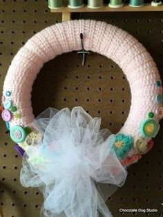 a knitted wreath with buttons and tulle