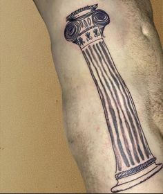 a man's leg with a tattoo on it that has a column in the middle