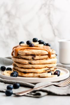 a stack of pancakes with blueberries and syrup