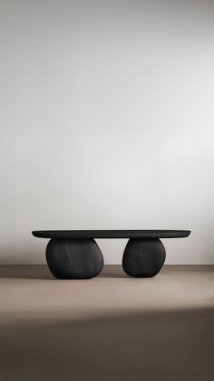 an oval table sitting on top of a wooden floor next to a white wall in the background