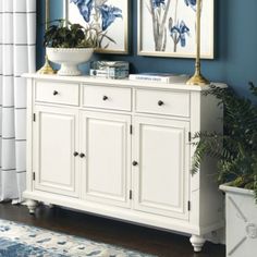 two blue and white vases sitting on top of a dresser next to a potted plant