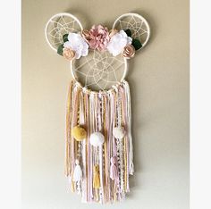 a wall hanging made out of yarn and flowers