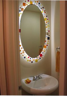 a bathroom sink sitting under a round mirror