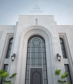 a large white building with a black door and two lights on the side of it