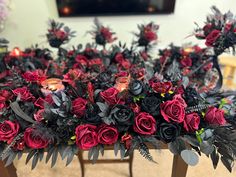 a table topped with lots of red and black flowers