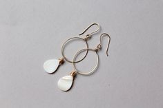 "These earrings are a little piece of ocean that you can always have. Shiny bright genuine white mother of pearl hoop earrings in 14k gold filled metal are a stunning piece of jewelry. Gold and white are the classic and elegant combination of colors. These are basic hoop earrings with a twist - shiny mother of pearl shell. With these earrings, it will be so easy to dress up even the simplest outfit. Total length approximately 3\" (7,5 cm) Mother of pearl is 18 x 13 mm. Gold filled is the next le Nickel-free White Hoop Pearl Earrings, Teardrop Mother Of Pearl Ear Wire Jewelry, Elegant Nickel-free Shell Earrings, White Teardrop Hoop Earrings Nickel Free, Elegant Mother Of Pearl Hoop Earrings Gift, White Teardrop Hoop Earrings As Gift, White Shell-shaped Hoop Earrings, Beach Bridesmaid, Double Horn Necklace