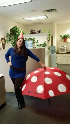 a woman in a blue dress is holding an umbrella with white polka dots on it