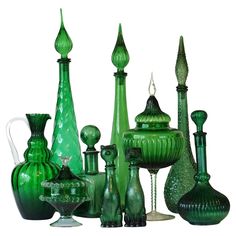 many green glass vases and other items on a white background