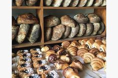 many different types of breads and pastries on display