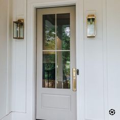 a white front door with two sidelights and a glass paneled window on the outside